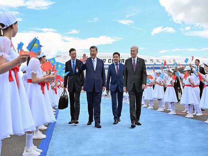 Chinese President is greeted by red and yellow aircraft smoke trails in Kazakhstan.
